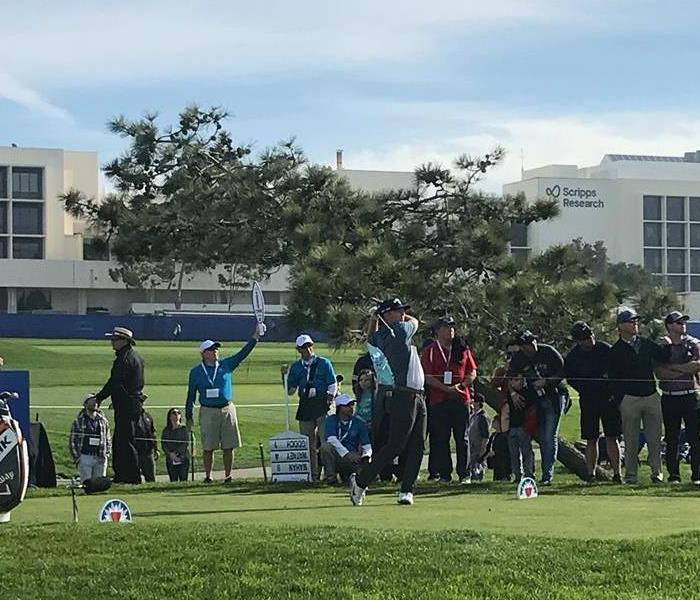 Crowd watching a man playing golf 
